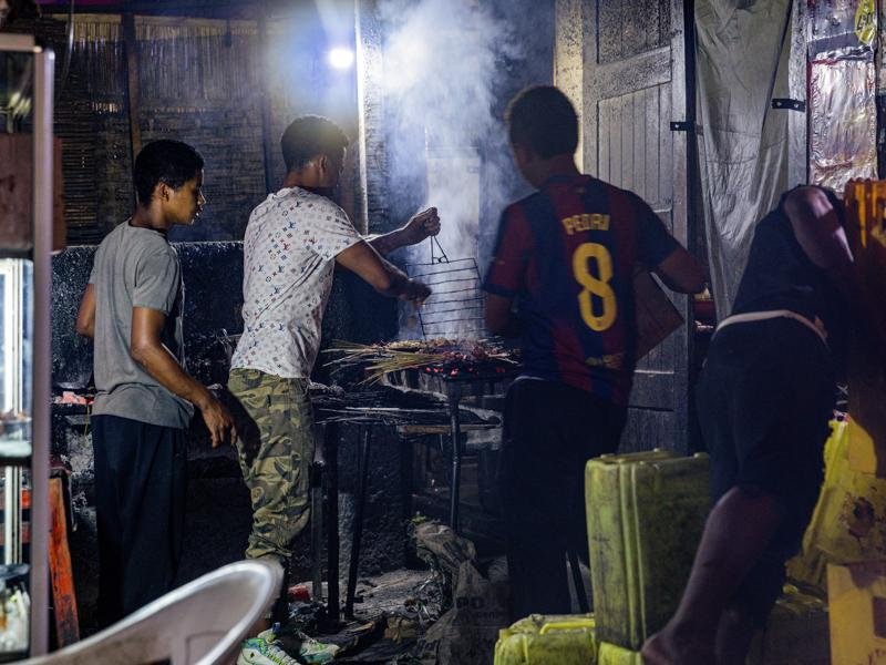 Meat skewers being grilled at a bar